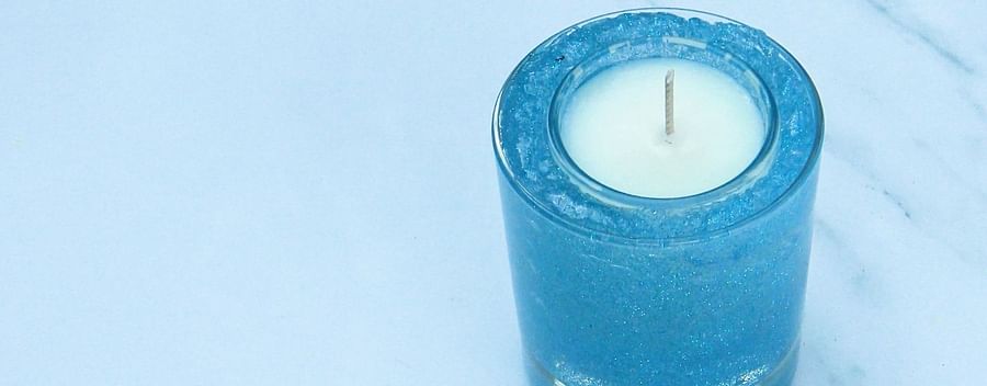 Various types of homemade gel wax candles glowing softly in a dimly lit room