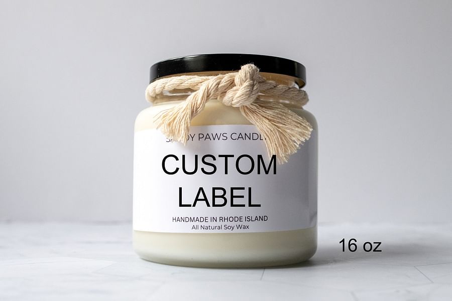 A collection of handmade candles with custom labels in various designs and colors